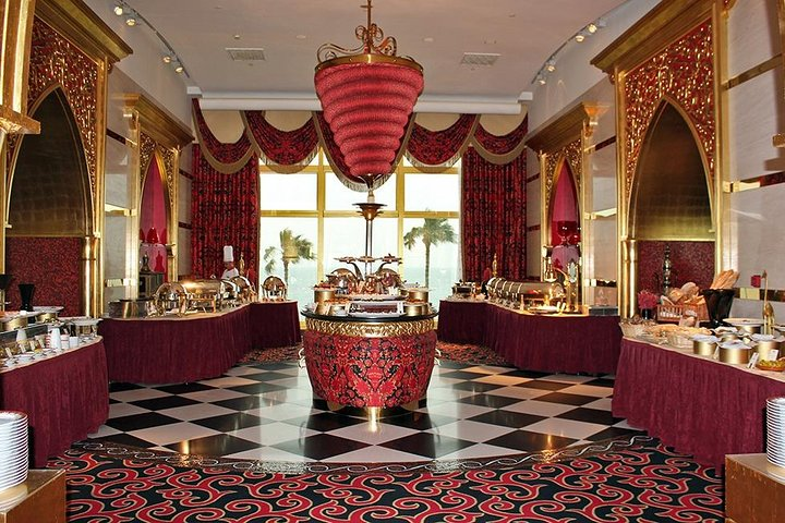 Experience the magic of Dubai at night while enjoying exquisite dining at Al Iwan where luxury and culinary delight meet against a stunning backdrop of the iconic Burj Al Arab.